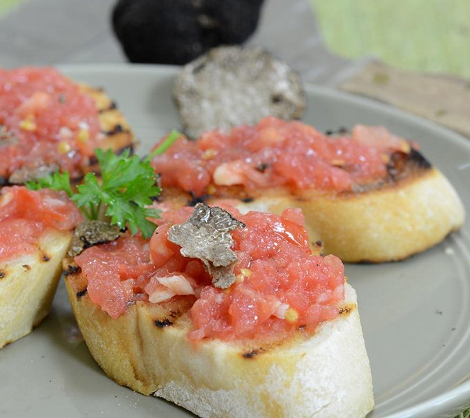 gourmet appetizer of toasted bread with tomato and fresh truffle