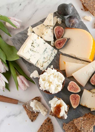  an assortment of cheeses on a board, gourmet food store