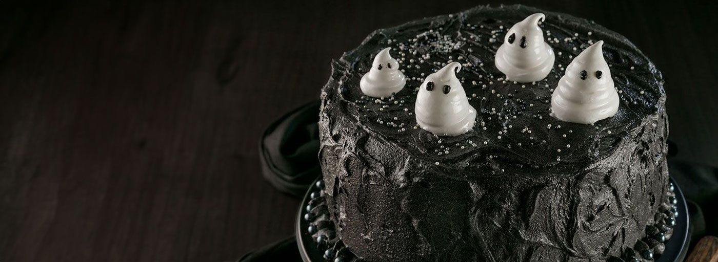 a black chocolate cake topped with white meringue ghosts, image by Gourmet Food Store